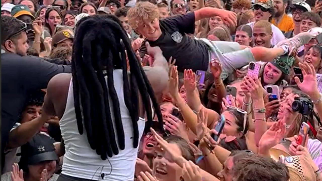 Adolescentes fazem crowd surfing para encontrar Shaboozey no Osheaga.